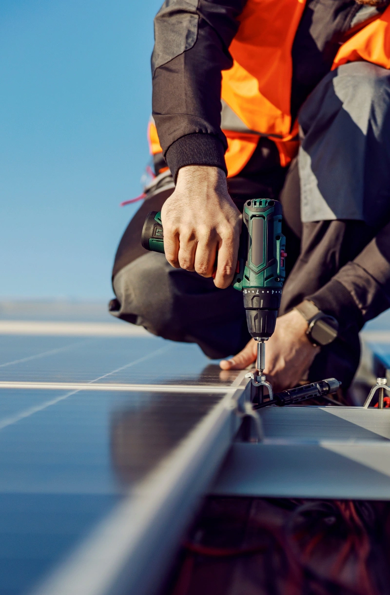 A person installing solar panels on a roof.
